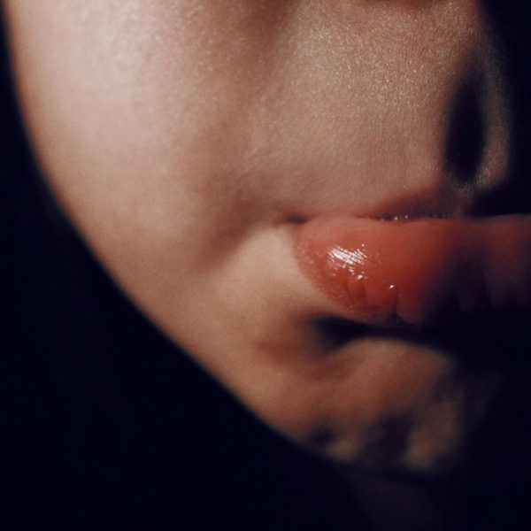 Cropped view of a light skinned person's cheek and pouting lip.