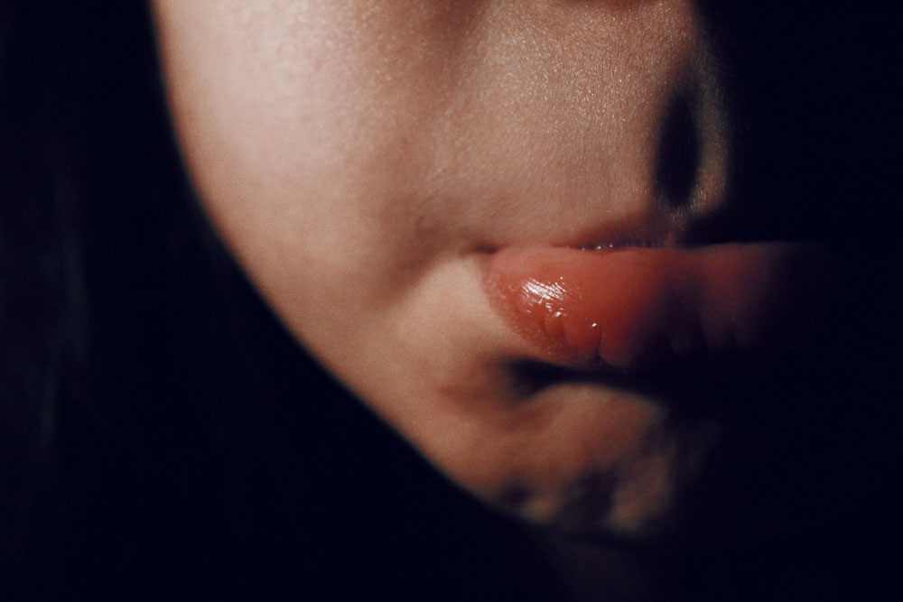 Cropped view of a light skinned person's cheek and pouting lip.