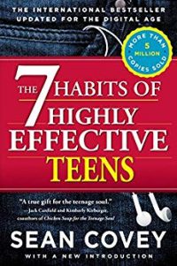 Book shows a close up of blue jean pocket with white earbuds hanging out of it. A red block highlights the title in white and yellow: "The 7 Habits of Highly Effective Teens". Above is "THE INTERNATIONAL BESTSELLER UPDATED FOR THE DIGITAL AGE" in white and "MORE THAN 5 MILLION COPIES SOLD" in a blue and yellow circle emblem. Below the title is "A true gift for the teenage soul." - Jack Canfield and Kimberly Krkberger, coauthors of Chicken Soup for the Teenage Soul" in white as well as "SEAN COVEY WITH A NEW INTRODUCTION."